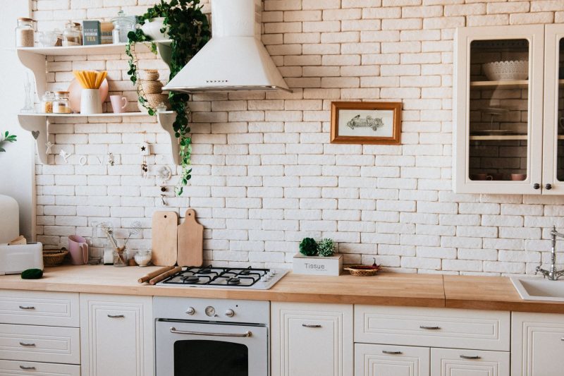 Stylish kitchen interior with modern appliances, wooden counters, and greenery accents